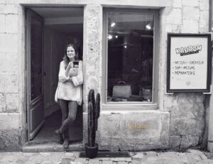 Lucie est devant la boutique de maroquinerie artisanale Kaboom maroquinerie au 9 rue Bletterie à La Rochelle