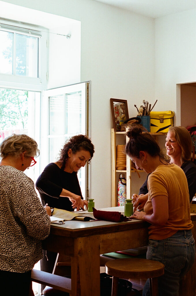 Plusieurs stagiaires en train de fabriquer un objet en cuir lors d'une initiation au travail du cuir chez Kaboom maroquinerie